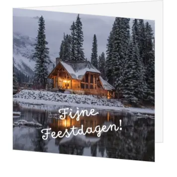 Kerstkaart met huis aan besneeuwd meer