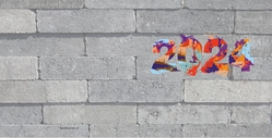 Gekleurde verfspatten op betonnen muur met jaartal